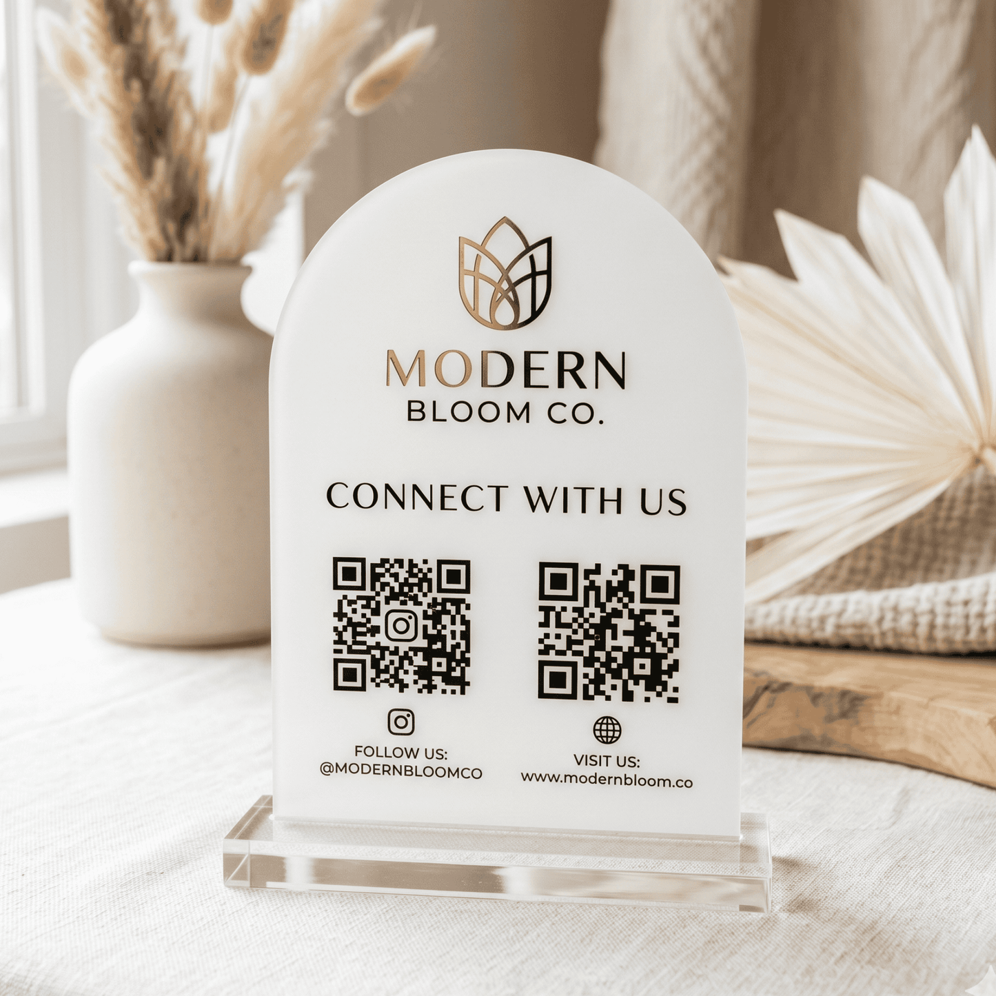 Modern Bloom Co. branded sign with QR codes on a decorative surface