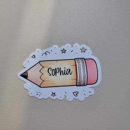 Sticker of a pencil with 'Sophia' on it attached to a textured surface