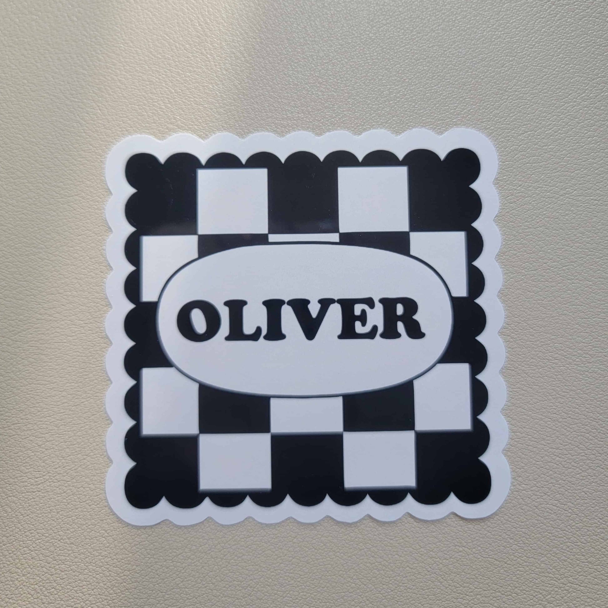 Sticker with 'OLIVER' text on a checkered design