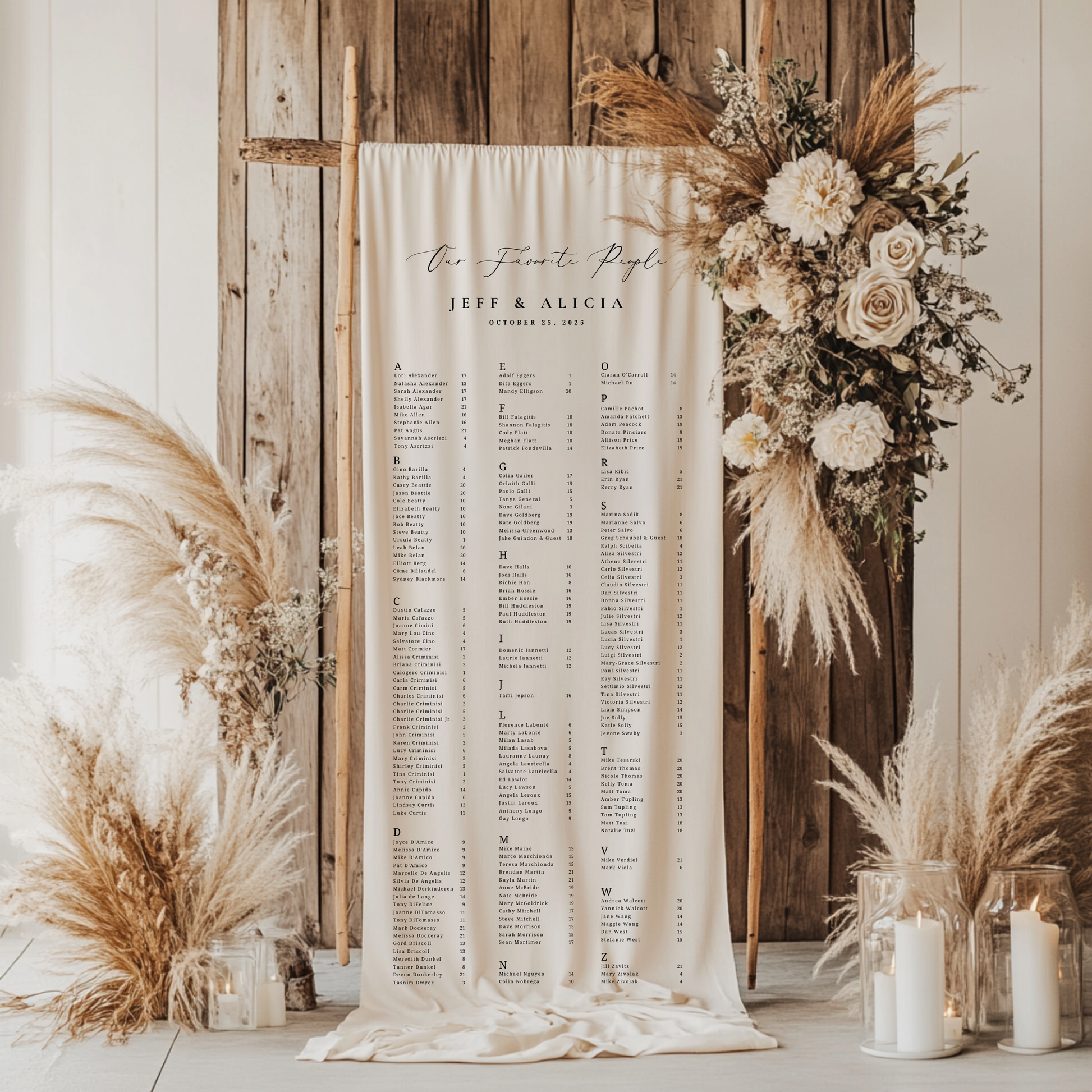 Seating chart with floral and pampas grass decorations against a wooden wall.