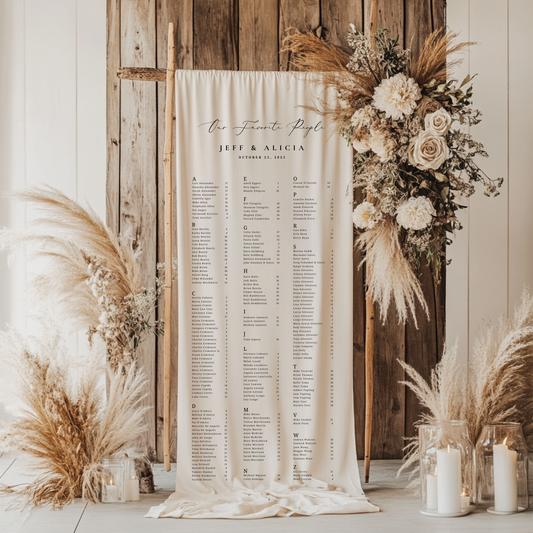 Seating chart with floral and pampas grass decorations against a wooden wall.