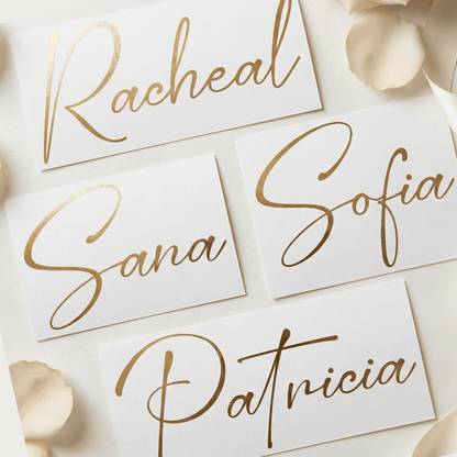 Gold cursive names on white cards with floral elements