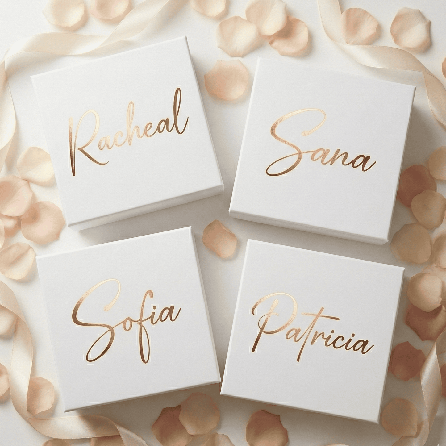 Four white boxes with gold names on a decorative background with petals and ribbons.