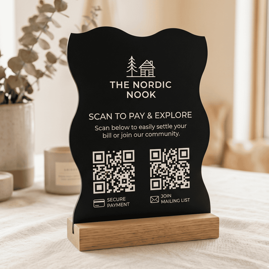 Black sign with QR codes and 'The Nordic Nook' branding on a wooden stand.