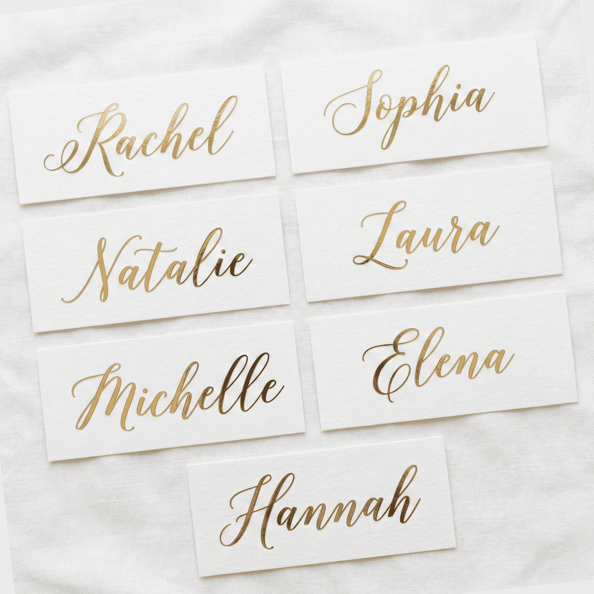 Gold name cards on a white fabric background