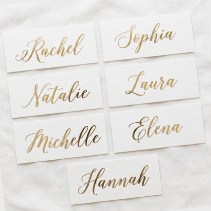 Gold name cards on a white fabric background